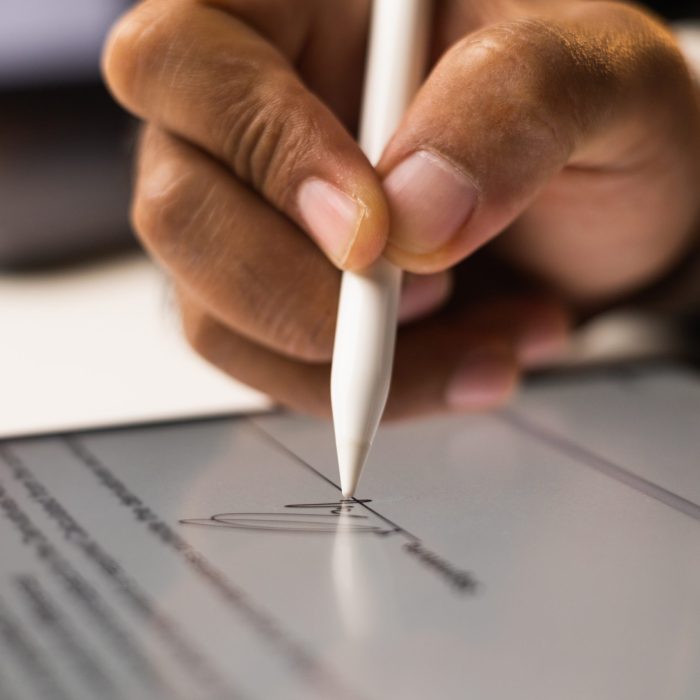 Close up businessman hand electronic Signature on Tablet by Stylus. Write business agreement of contract. Man signing contract on tablet. Business and technology concept.