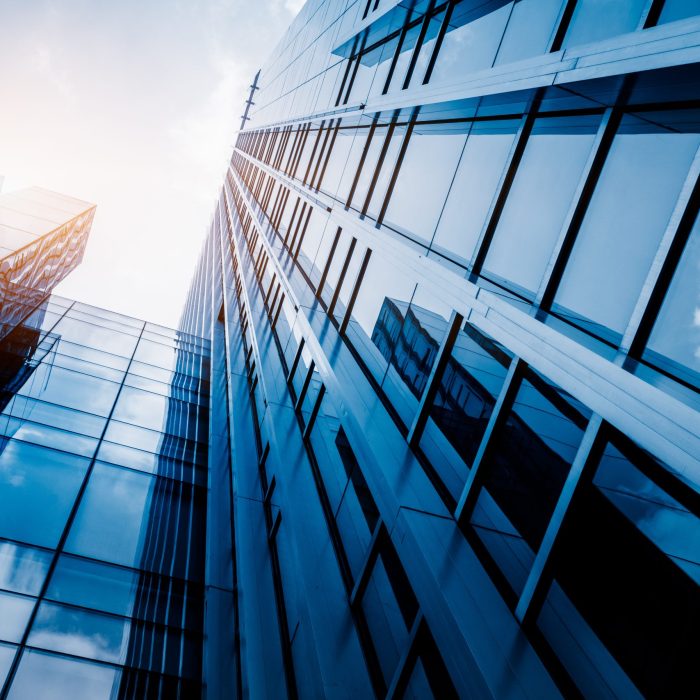 Modern office building against blue sky, blue tone.