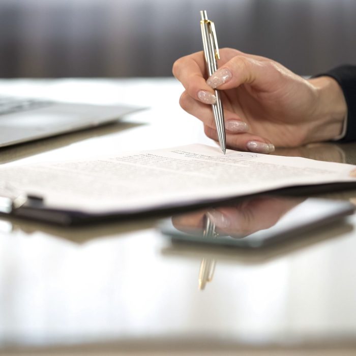 Woman in suit reading terms and conditions of agreement, signing contract, stock footage